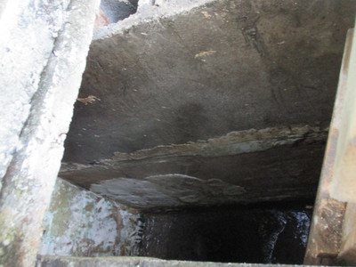 interior of water tank
drained with muck covering the bottom and plaster flaking from walls