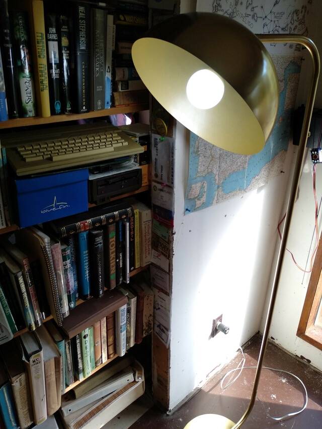 front view of lit lamp beside a bookcase